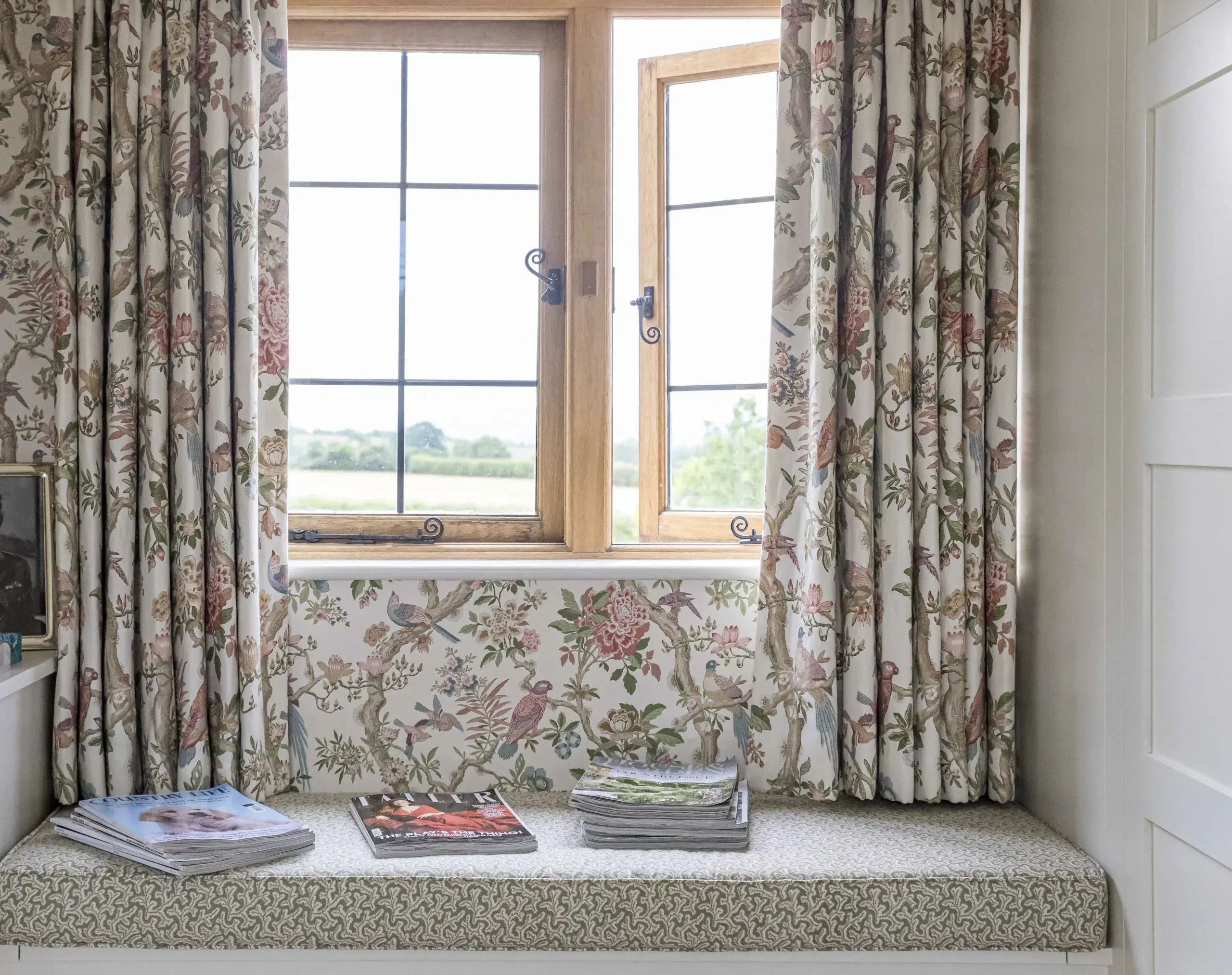 Window seat with floral curtains and countryside view